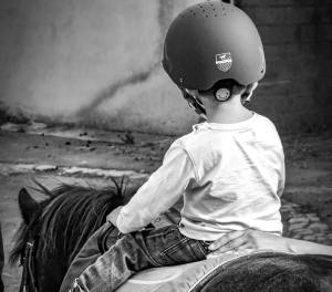 Enfant à poney dans un manège aux écuries fidelis